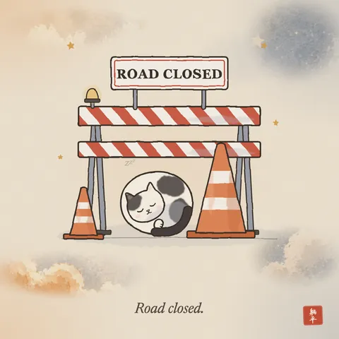 A striped road barrier with a sign reading ROAD CLOSED and an orange traffic cone. A black-and-white cat is curled up asleep at the foot of the cone. Caption: Road closed.